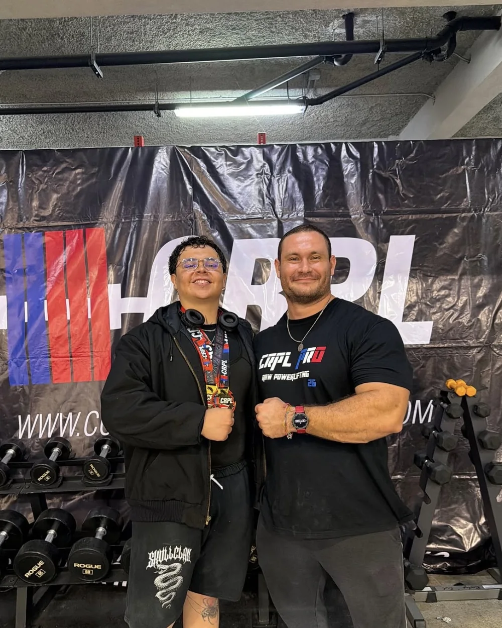An athlete coached by Douglas Lutz holding a CRPL medal next to him after the meet