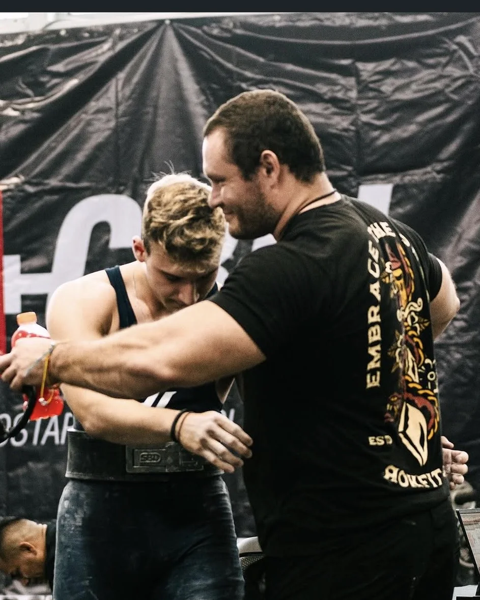 Douglas Lutz supporting one of his athletes immediately after a lift at a competition