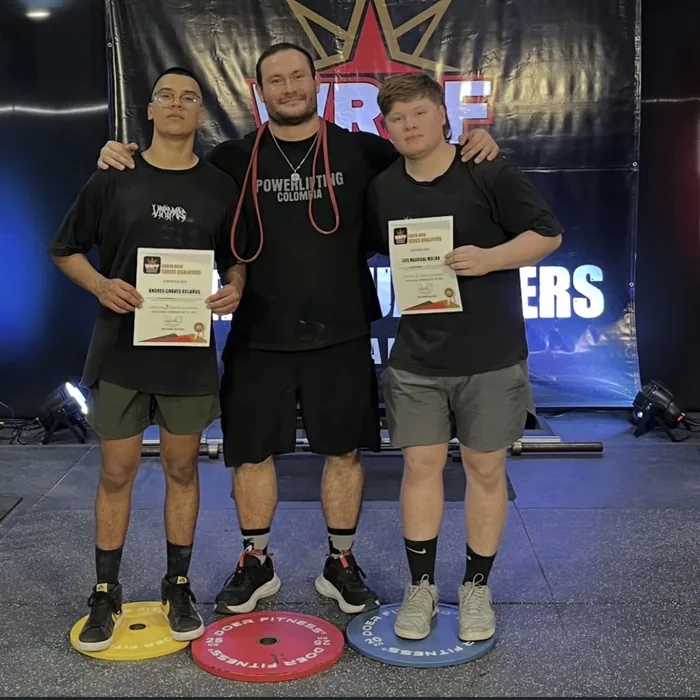 Two athletes coached by Douglas Lutz on the podium with their qualifier certificates